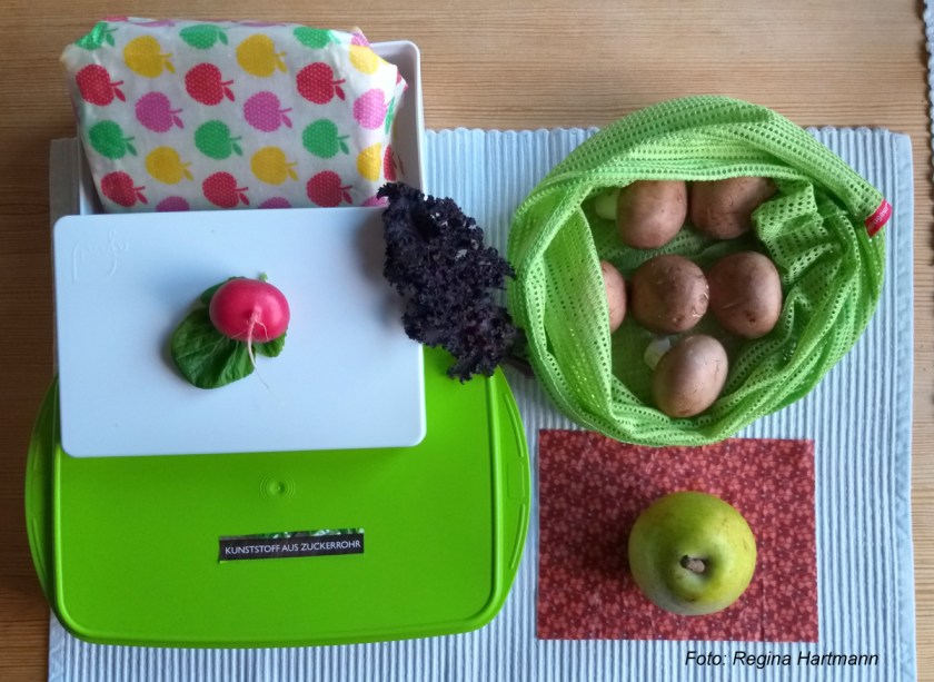 Eine Dose aus Zuckerrohr, Wachspapier für Käse und Wurst und Stoffsäckchen für Obst und Gemüse - Einkaufsalternativen helfen Verpackung einzusparen.