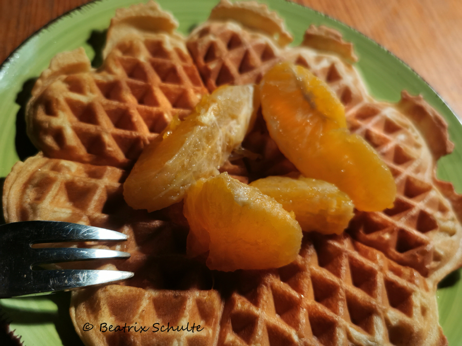 Waffeln mit Orangenzesten und warmen Orangenspalten